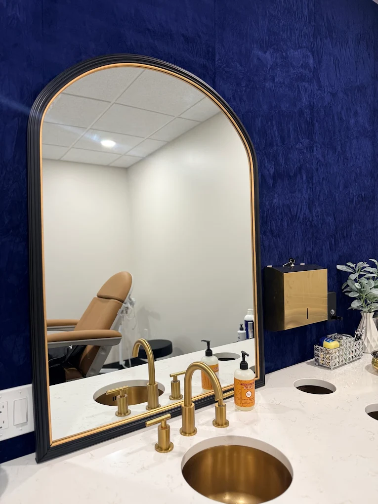 Blue feature wall, arched mirror and gold fixtures inside Prim